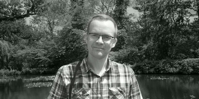 Photo portrait of Matt Hill, smiling against a backdrop of trees